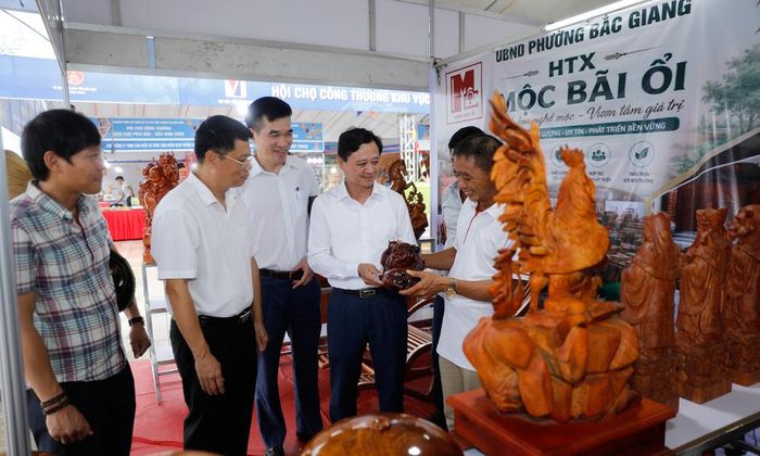  Đại diện Ban Tổ chức hội chợ kiểm tra hoạt động trưng bày sản phẩm tại gian trưng bày của Hợp tác xã Mộc Bãi Ổi, phường Bắc Giang. 