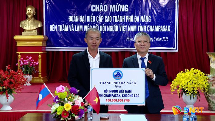 Chủ tịch HĐND thành phố Nguyễn Đức Dũng (bên phải) trao hỗ trợ cho Hội Người Việt tỉnh Champasak. Ảnh: HOÀN VŨ - VĂN HÙNG
