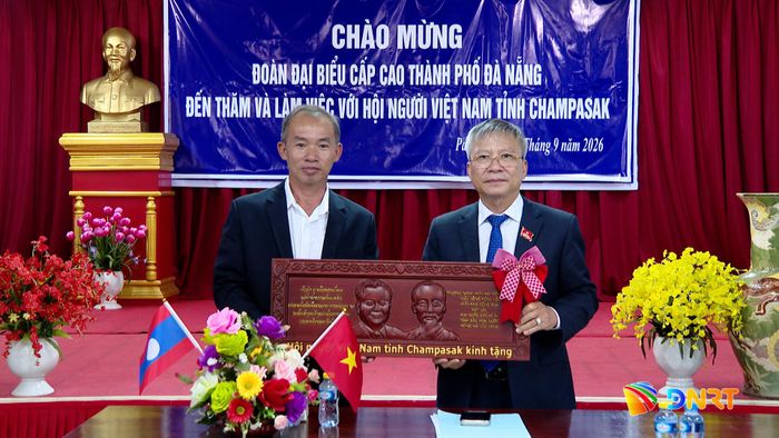 Đại diện Hội Người Việt tại tỉnh Champasak tặng quà cho đoàn công tác. Ảnh: HOÀN VŨ - VĂN HÙNG
