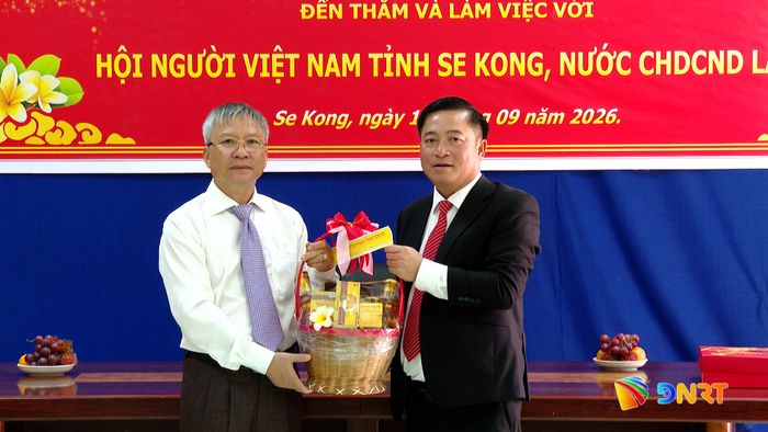 Đại diện Hội Người Việt Nam tỉnh Sê Kông tặng quà lưu niệm cho đoàn công tác. Ảnh: HOÀN VŨ - VĂN HÙNG