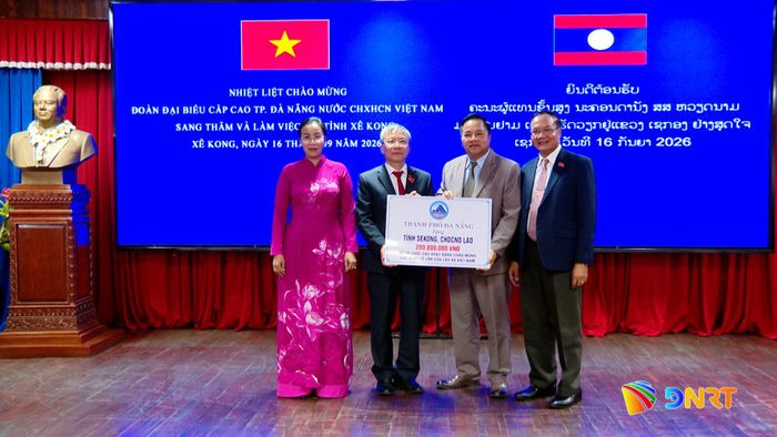 Lãnh đạo thành phố trao hỗ trợ 200 triệu đồng để tỉnh Sê Kông tổ chức các hoạt động chào mừng những ngày lễ lớn của Lào và Việt Nam. Ảnh: HOÀN VŨ - VĂN HÙNG