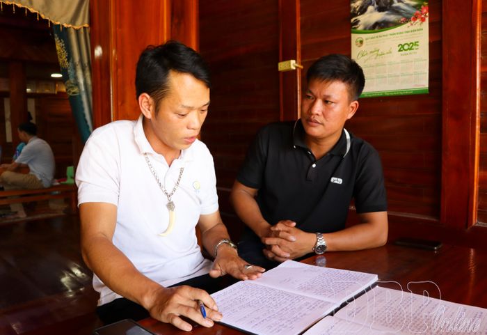 Bí thư Chi bộ bản Huổi Thanh 1 Đặng Văn Néng (áo trắng) trao đổi công việc với đảng viên Bàn Văn Hòa.