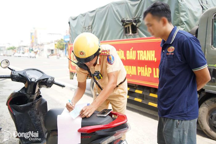 Lực lượng cảnh sát giao thông lập biên bản các trường hợp vi phạm được phát hiện trong quá trình tuần tra, kiểm soát trên tuyến quốc lộ 1. Ảnh: Lê Duy