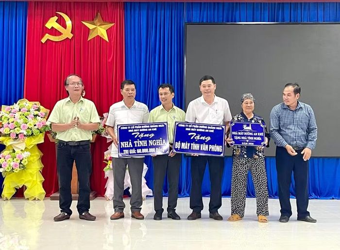 Đại diện Nhà máy Đường An Khê trao bảng tượng trưng hỗ trợ bộ máy tính văn phòng và nhà tình nghĩa tại xã SRó. Ảnh: P.D