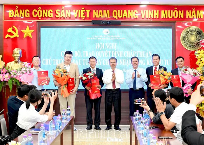 Phó Chủ tịch UBND tỉnh Trần Hòa Nam và lãnh đạo Ban Quản lý Khu kinh tế và Khu công nghiệp tỉnh trao giấy chứng nhận đăng ký đầu tư và tặng hoa chúc mừng các nhà đầu tư.