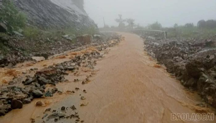 Mưa lớn khiến đất đá trôi xuống đường gây khó khăn cho các phương tiện tham gia giao thông.