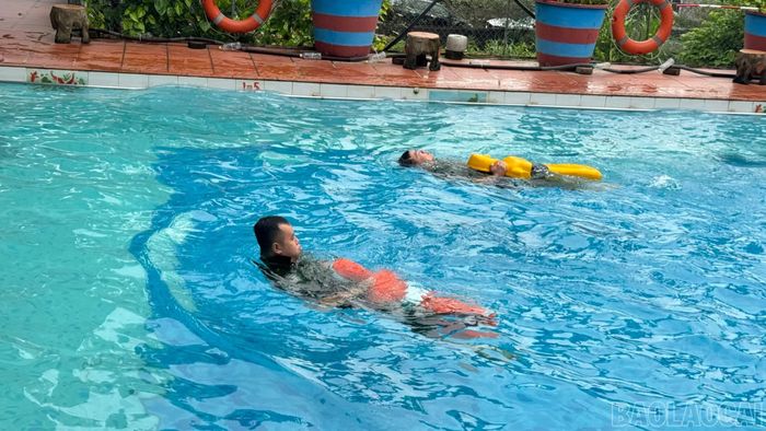 Các học viên thực hành cứu nạn người bị đuối nước tại bể bơi.