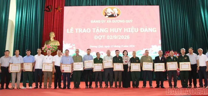 Thường trực Đảng ủy xã Dương Quỳ trao Huy hiệu Đảng cho các đảng viên.