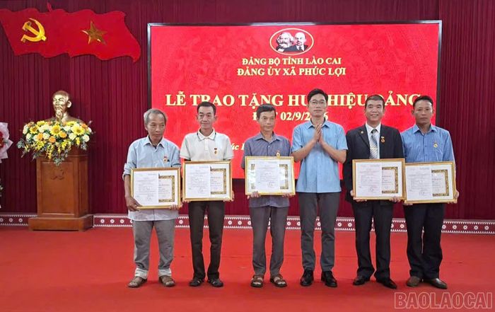 Thường trực Đảng ủy xã Phúc Lợi trao Huy hiệu Đảng cho các đảng viên.