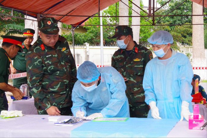 Trung úy Quân nhân chuyên nghiệp Đặng Hữu Sang (thứ 3 từ phải qua) trong lúc thực hiện nhiệm vụ lấy mẫu