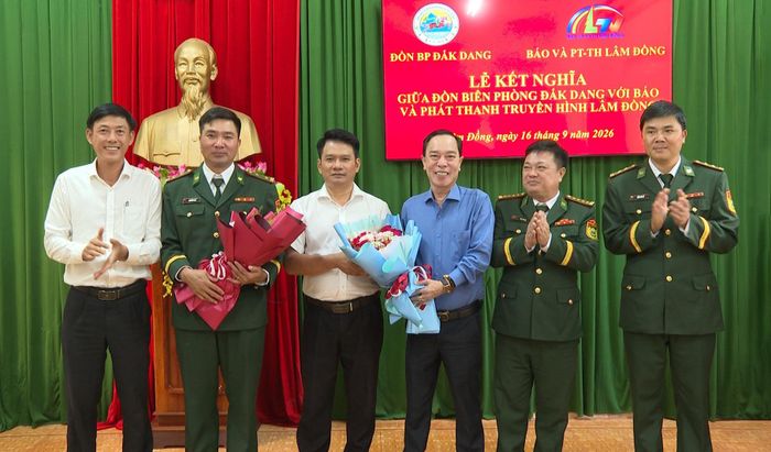 Đồng chí Dương Huy Toàn, Tỉnh ủy viên, Bí thư Đảng ủy xã Quảng Trực (ngoài cùng bên trái) và Đại tá Đinh Văn Bộ, Ủy viên Ban Thường vụ Đảng ủy, Phó Chính ủy Bộ đội Biên phòng tỉnh Lâm Đồng (thứ 2 từ phải qua) tặng hoa chúc mừng hai đơn vị kết nghĩa
