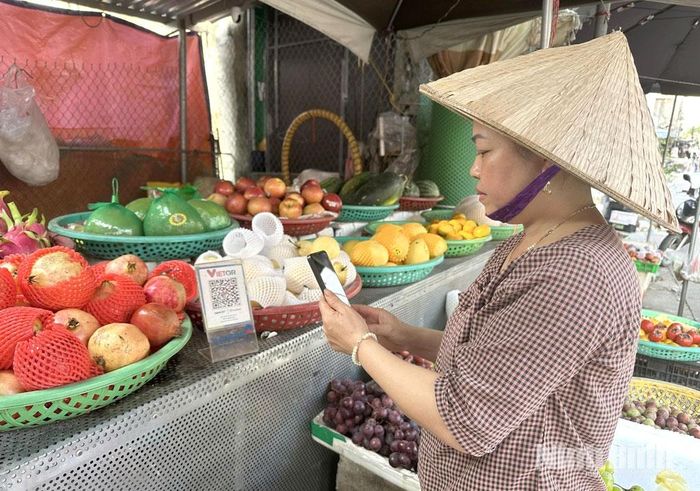 Người dân xã Tân Thanh sử dụng phương thức quét mã QR để thanh toán khi đi mua sắm.