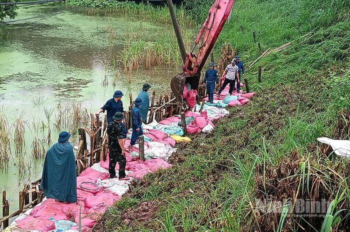 Đắp bao cát gia cố chân đê tại điểm sạt trượt.