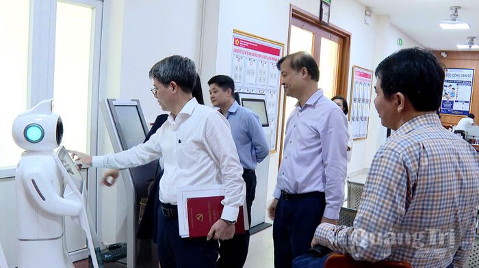 Đồng chí Nguyễn Hoa Cương, Phó Viện trưởng Viện Nghiên cứu chính sách và chiến lược Trung ương và đoàn công tác tìm hiểu việc ứng dụng công nghệ Robot AI tại phường Đồng Hới - Ảnh: H.Tr