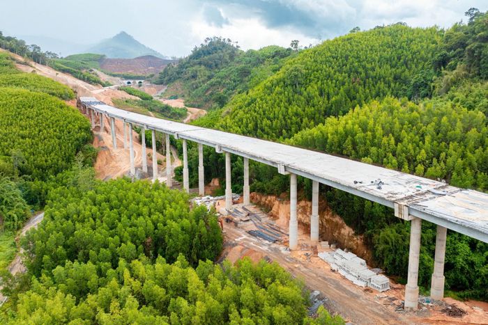 Để tổ chức thi công, việc tiếp cận công địa rất khó khăn do địa hình đồi núi, dốc cao, vực sâu và thủ tục chuyển mục đích sử dụng rừng mất gần 1 năm. Theo kế hoạch, đến 30/10/2026, nhà thầu sẽ hoàn thành bê tông nhựa mặt đường và bê tông vỏ hầm trái, đến 10/12 sẽ hoàn thành nền mặt đường và bê tông vỏ hầm phải để lắp đặt các thiết bị cơ điện.