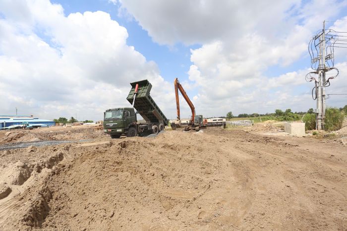 Cách vị trí cầu vượt khoảng 1km, tại nút giao với tỉnh lộ 8, công nhân đang khẩn trương san lấp mặt bằng, xử lý nền đất yếu, chuẩn bị cho các hạng mục tiếp theo.