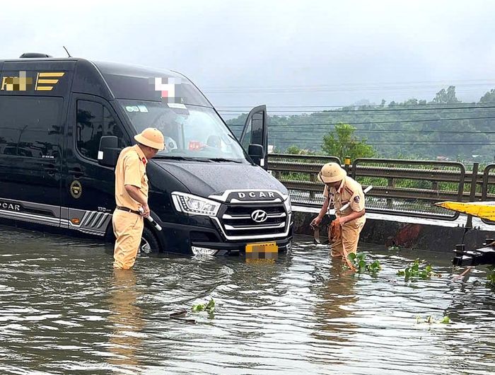 Cảnh sát giao thông hỗ trợ cứu hộ xe ô tô ra khỏi vị trí ngập nước.