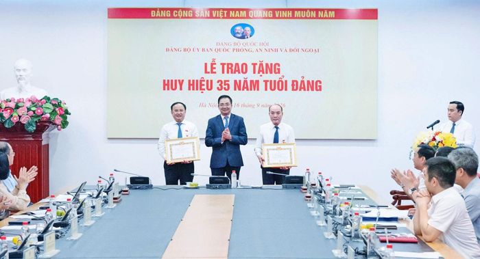Phó Bí thư Đảng uỷ, Phó Chủ nhiệm Ủy ban Quốc phòng, An ninh và Đối ngoại, Trung tướng Nguyễn Minh Đức đã trao Quyết định và tặng Huy hiệu 35 năm tuổi Đảng cho Trung tướng Trần Đức Thuận và đồng chí Vũ Hồng Lưu. Ảnh: Đắc Trường