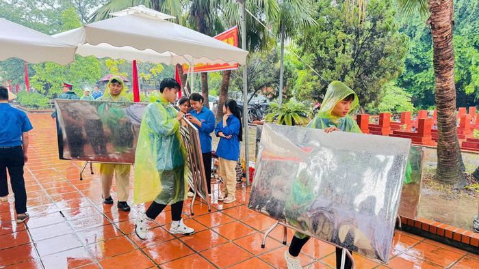 Đoàn viên, thanh niên Ô Diên tích cực hỗ trợ công tác chuẩn bị tại nghĩa trang trong thời tiết mưa. Ảnh: PV