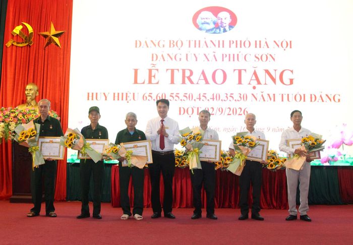 Phó Bí thư Thường trực Đảng ủy xã Phúc Sơn Trần Việt Thắng trao Huy hiệu Đảng tặng đảng viên trên địa bàn. Ảnh: Kim Nhuệ