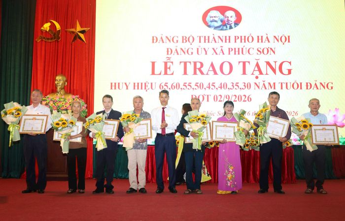 Phó Bí thư Đảng ủy, Chủ tịch UBND xã Phúc Sơn Ngô Quốc Ca trao Huy hiệu Đảng tặng các đảng viên trên địa bàn. Ảnh: Kim Nhuệ