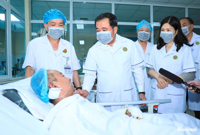 Bí thư Thành ủy Hà Nội Trần Đức Thắng và lãnh đạo thành phố thăm hỏi nạn nhân đang điều trị tích cực tại Bệnh viện Quân y 354. Ảnh: Quang Thái.