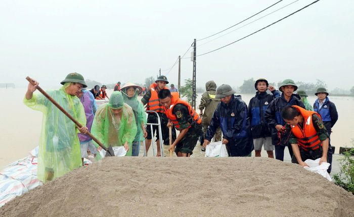 Hàng trăm người dân xã Trần Phú và chiến sĩ quân đội chống tràn đê sông Bùi. Ảnh: Hồng Đào