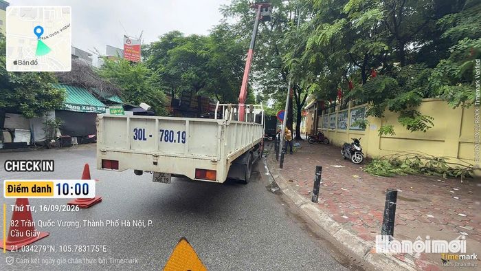 Lực lượng chức năng phường Cầu Giấy tổ chức khắc phục sự cố đèn chiếu sáng gãy, nghiêng. Ảnh: Vân Nhi