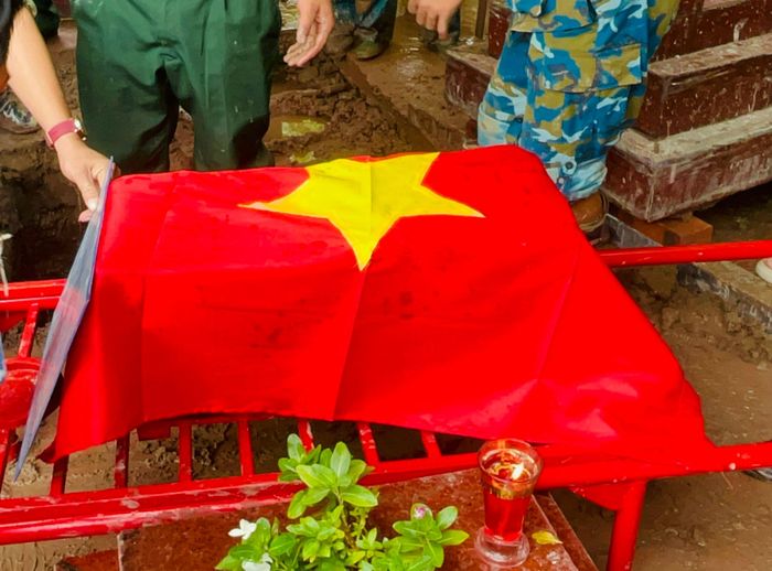 Quốc kỳ phủ trên phần hài cốt, biểu tượng của lòng tri ân với người đã hy sinh. Ảnh: Ánh Bình