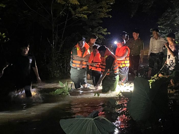 Công an, bộ đội xã Tam Thái, Nghệ An hỗ trợ một phụ nữ vượt nước lũ đi cấp cứu tối 15/9 - Ảnh: CSCC.