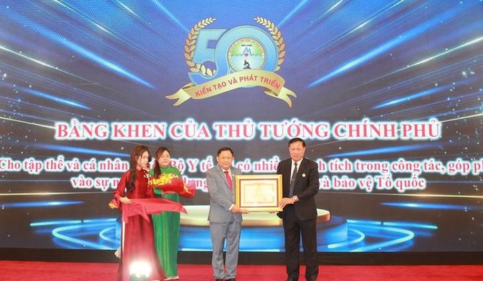 Thứ trưởng Bộ Y tế Đỗ Xuân Tuyên trao TS. Giang Hán Minh Bằng khen của Thủ tướng Chính phủ.Ảnh: Mimosa