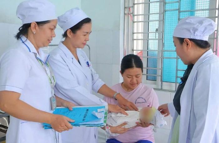 Bác sĩ BVĐK Vĩnh Long thăm động viên mẹ và con sản phụ. Ảnh: BVCC.