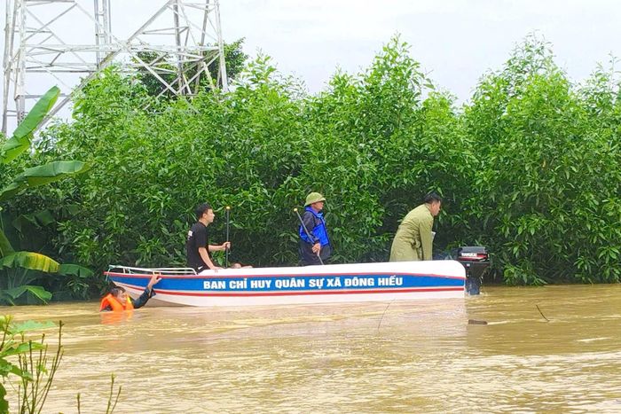 Lực lượng Ban Chỉ huy Quân sự xã Đông Hiếu dùng thuyền tiếp cận, hỗ trợ người dân trong vùng ngập lụt. Ảnh: Trí Hưởng.