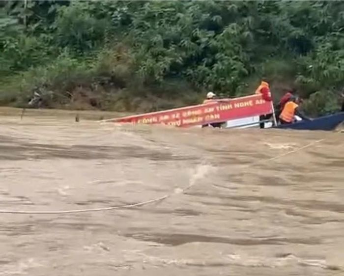 Người dân mặc áo phao được lực lượng chức năng hỗ trợ đưa lên bờ an toàn - Ảnh: Bạn đọc cung cấp.
