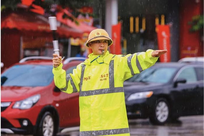 Dưới màn mưa, màu vàng của sắc phục Cảnh sát giao thông luôn nổi bật để bảo đảm an toàn giao thông