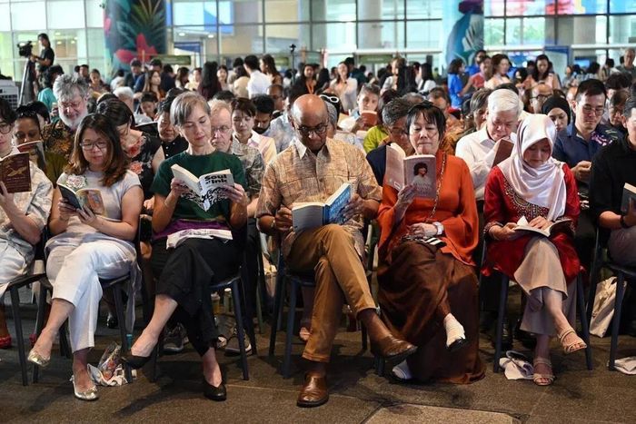  Tổng thống Singapore Tharman Shanmugaratnam (giữa) và phu nhân Jane Ittogi Shanmugaratnam (giữa, bên phải) đọc sách. Ảnh: Straits Times. 
