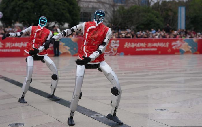 Robot Tesla Optimus và Unitree Robotics của Trung Quốc. Ảnh: Reuters/Xinhua.