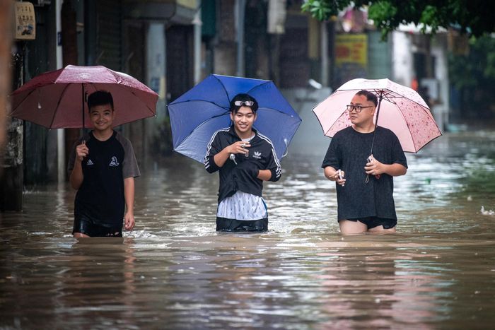  Nguyễn Anh Tùng (19 tuổi, ở giữa) phải nghỉ học sáng nay do nhiều cung đường tới trường bị ngập sâu. Nam sinh viên tranh thủ thời điểm mưa ngớt để bắt xe lên Trường Đại học Thương Mại cách nhà 10 km. "Tôi dự định ngủ qua đêm ở trường từ hôm nay vì nếu mai mới bắt đầu xuất phát từ nhà đi học sẽ rất vất vả", Tùng nói. 