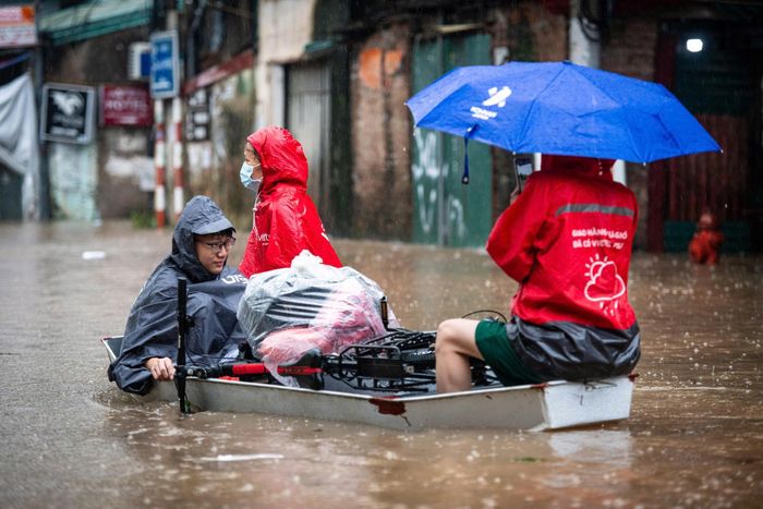  Người Hà Nội di chuyển bằng thuyền trong cơn mưa kéo dài sáng 17/9. Ảnh: Đinh Hà, Viết Huy. 