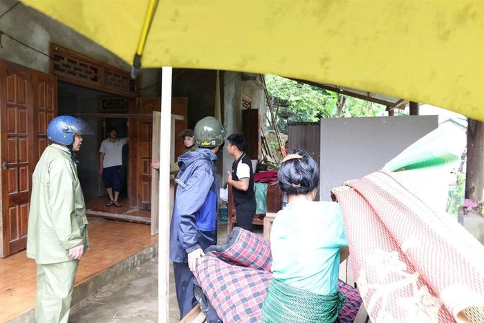 Các lực lượng chức năng và Ban quản lý bản hỗ trợ người dân di chuyển đồ đạc sang nhà hàng xóm để bảo đảm an toàn
