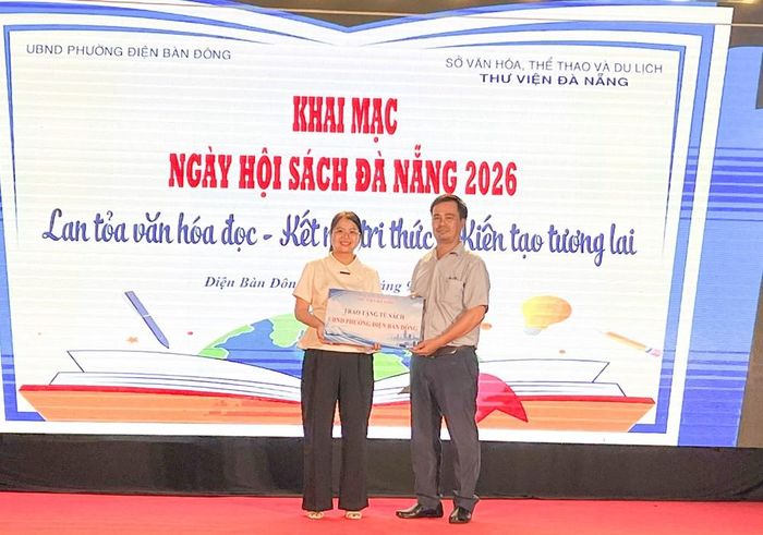 Đại diện Thư viện Đà Nẵng (bên phải) trao tặng tủ sách cho đại diện Trung tâm Cung ứng dịch vụ sự nghiệp công phường Điện Bàn Đông