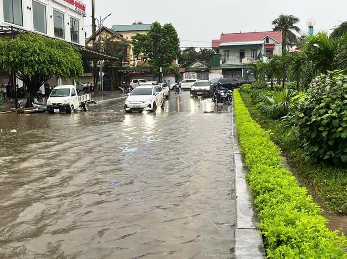 Phương tiện di chuyển khó khăn do đường bị ngập sâu trong nước. Ảnh: Khiếu Tư - TTXVN