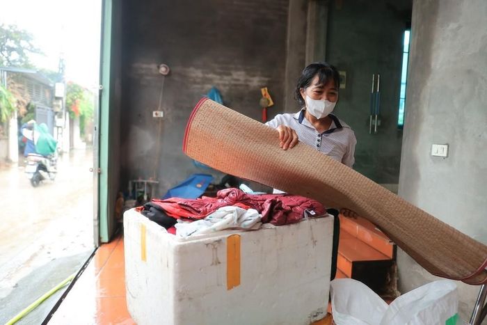 Người dân thôn Ninh Kiều (xã Quảng Bị) kê đồ dùng lên vị trí cao phòng nước dâng. Ảnh: Minh Quyết - TTXVN