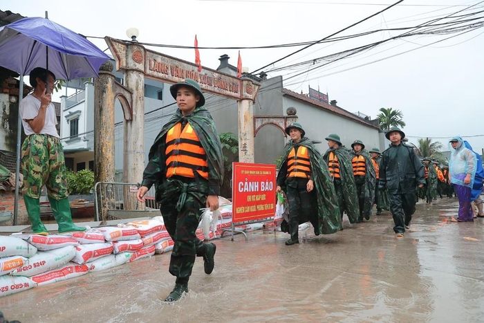 Cán bộ, chiến sĩ Trung đoàn 12, Sư đoàn 308 hỗ trợ đắp đê khu vực thôn Ninh Kiều (xã Quảng Bị). Ảnh: Minh Quyết - TTXVN
