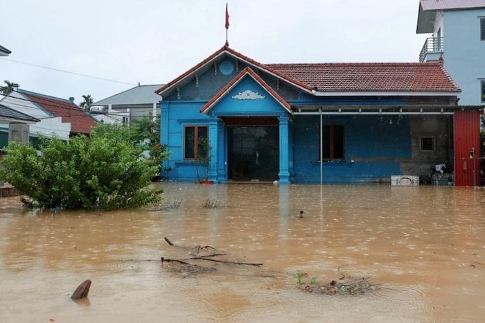 Nước lũ dâng cao tràn vào sân và bao vây nhà dân tại xã Quảng Bị, Hà Nội. Ảnh: Phạm Tuấn Anh - TTXVN