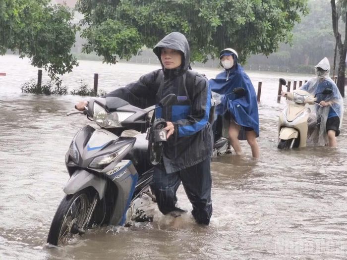 Hồ Văn Quán ngập sâu khiến nhiều người phải dắt xe lội bộ. Ảnh: THIÊN LAM