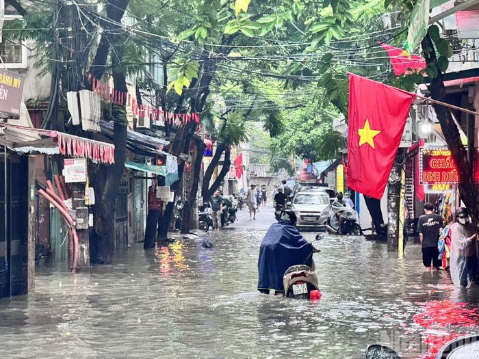 Nhiều người đã phải dắt xe do chết máy trên phố Hoa Bằng (Cầu Giấy). Ảnh: THẾ ĐẠI