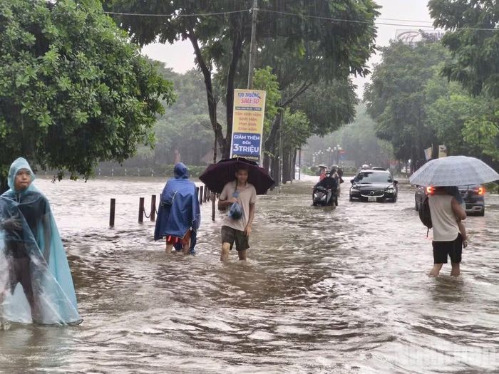 Hồ Văn Quán ngập sâu khiến nhiều người phải dắt xe lội bộ. Ảnh: THIÊN LAM