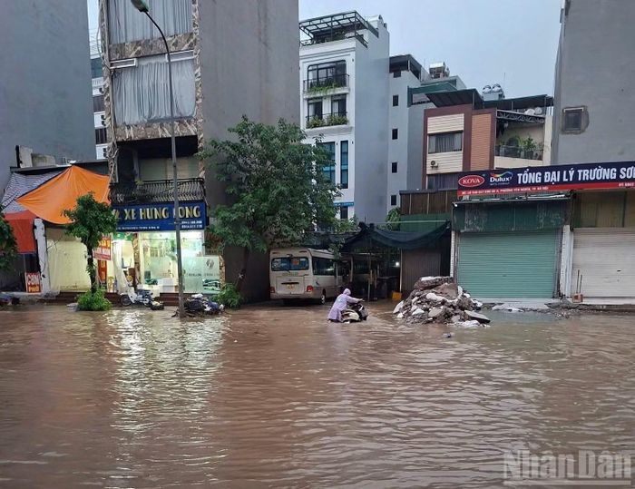 Nhiều khu vực tại phường Yên Nghĩa ngập sâu tới hàng chục cm, khiến người dân đi lại chật vật. Ảnh: VĂN TOẢN