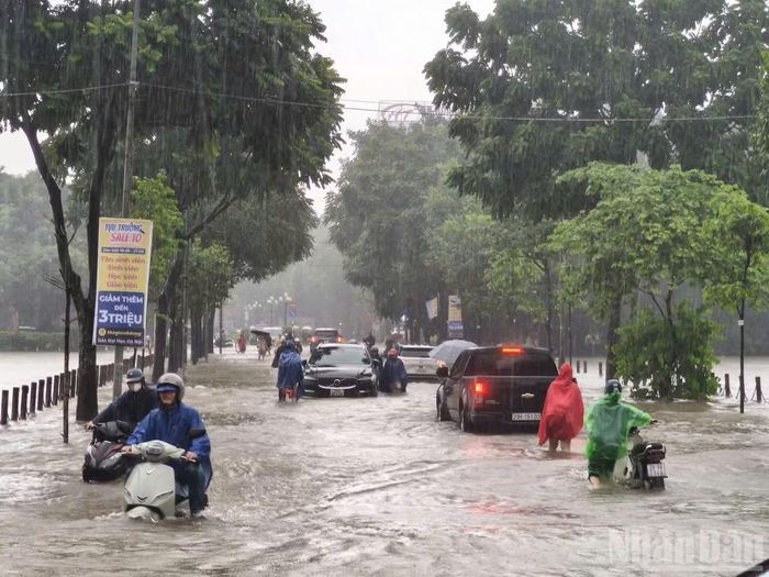 Hồ Văn Quán ngập sâu khiến nhiều người phải dắt xe lội bộ. Ảnh: THIÊN LAM